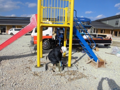 設置完了した遊具の基礎部にモルタルを詰め込んで固定しています